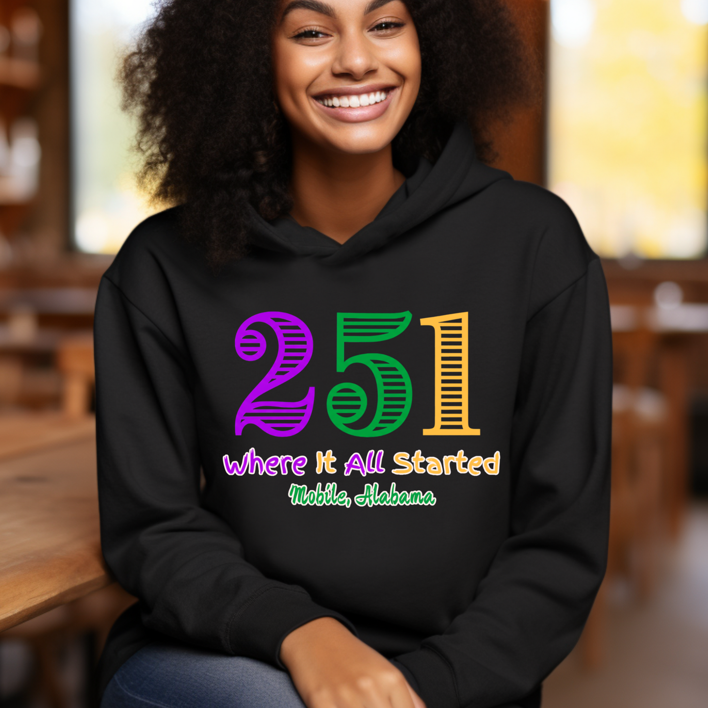 Person wearing a black hoodie with colorful text in an indoor setting