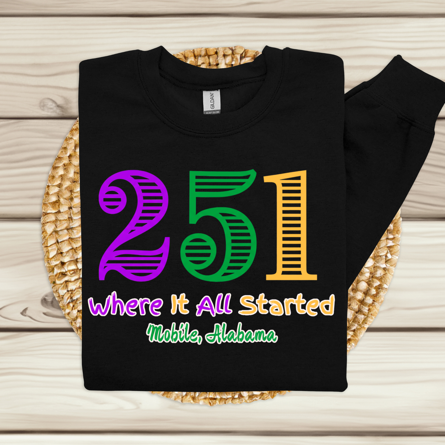 Black sweatshirt with colorful text on a woven mat