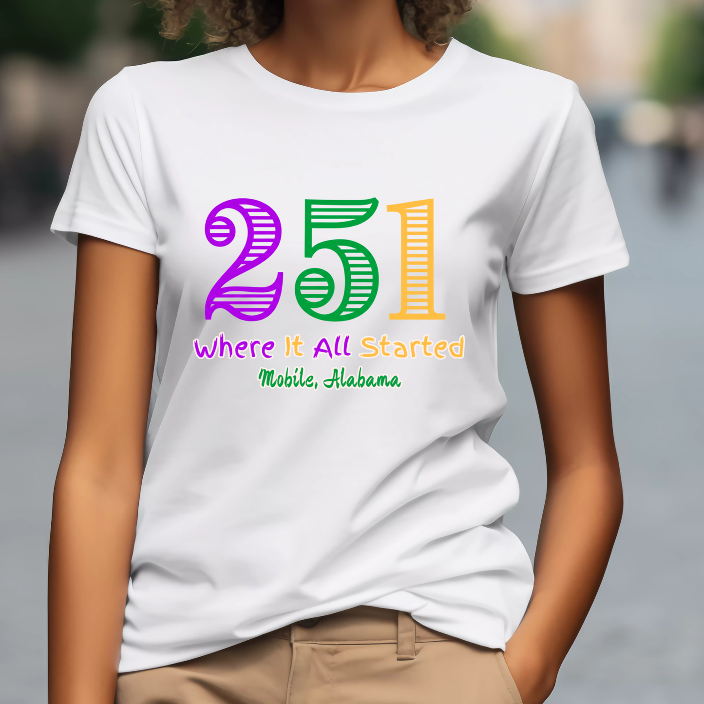 Person wearing a white t-shirt with colorful text '251' and 'Where It All Started Mobile, Alabama'.