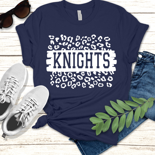 Navy blue t-shirt with 'KNIGHTS' design on a wooden surface with shoes and jeans. Knights School Spirit Shirt - Knights Leopard - School Pride Graphic T-Shirt