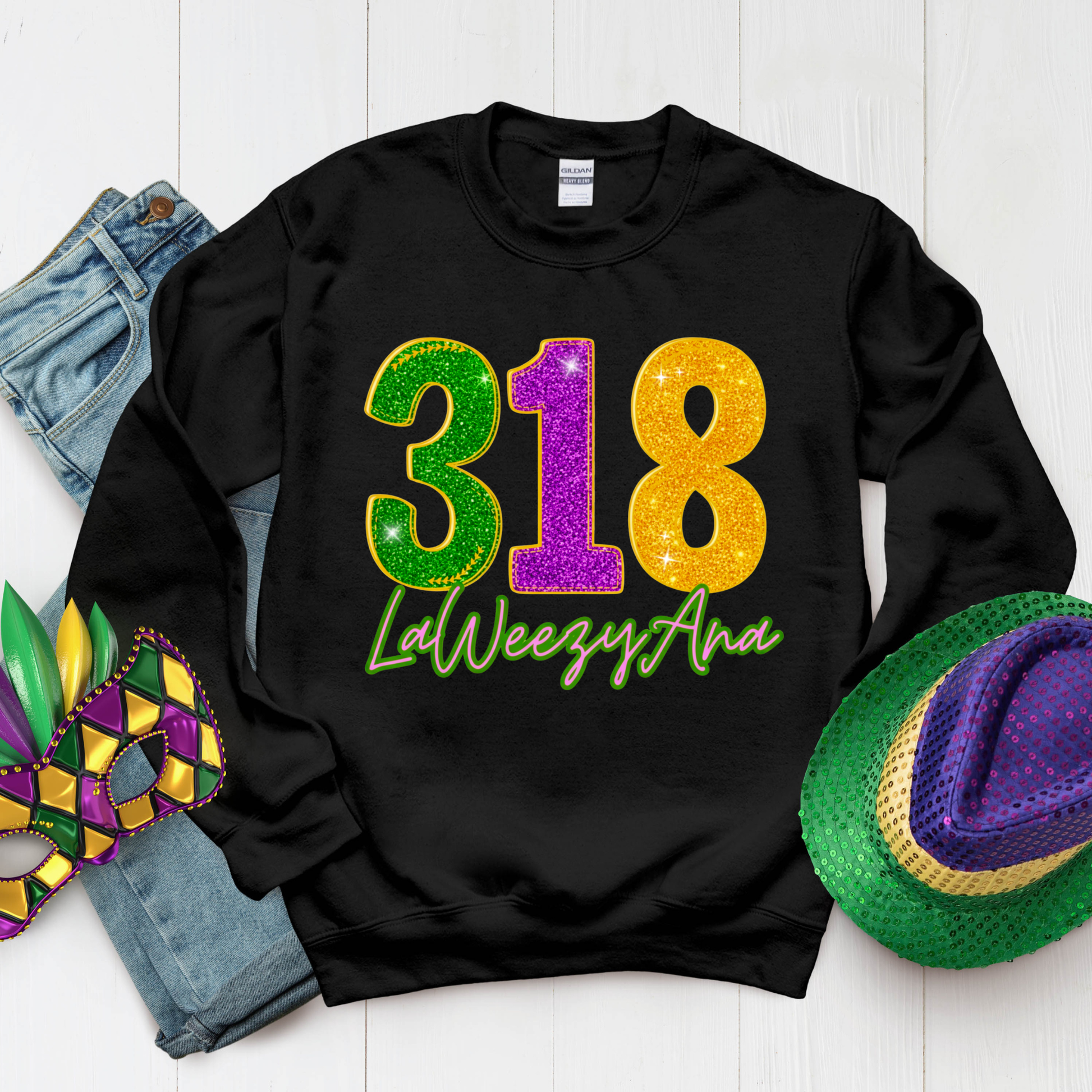 Black sweatshirt with colorful '318 LaWeezyAna' text, surrounded by Mardi Gras-themed items on a white background.