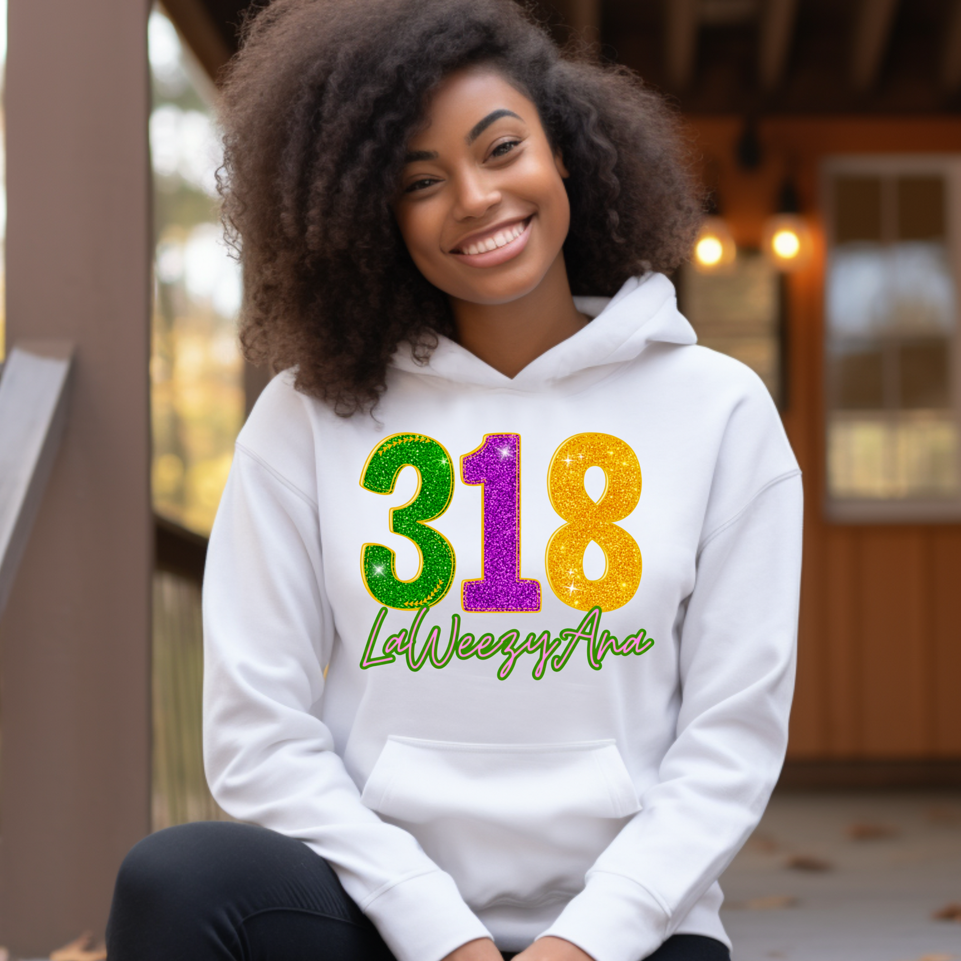 Person wearing a white hoodie with colorful text sitting outdoors.