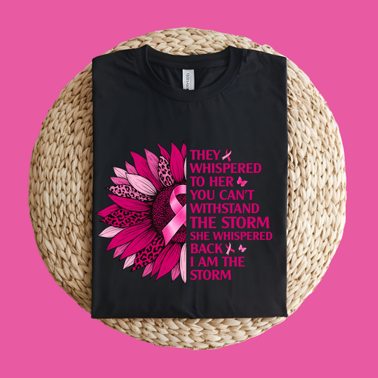 Black t-shirt with pink floral design and text on a woven mat with a pink background