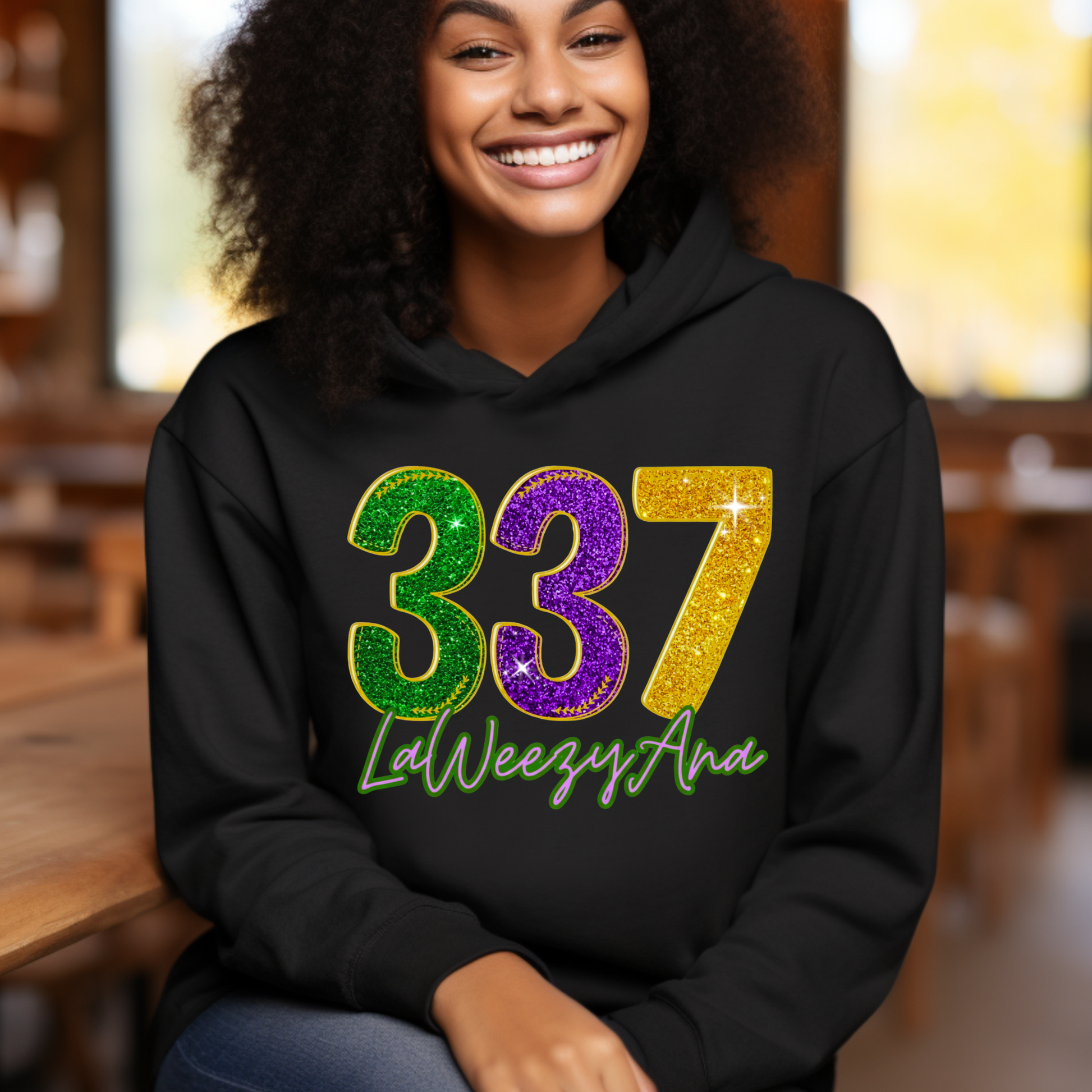 Person wearing a black hoodie with colorful numbers and text, sitting indoors.