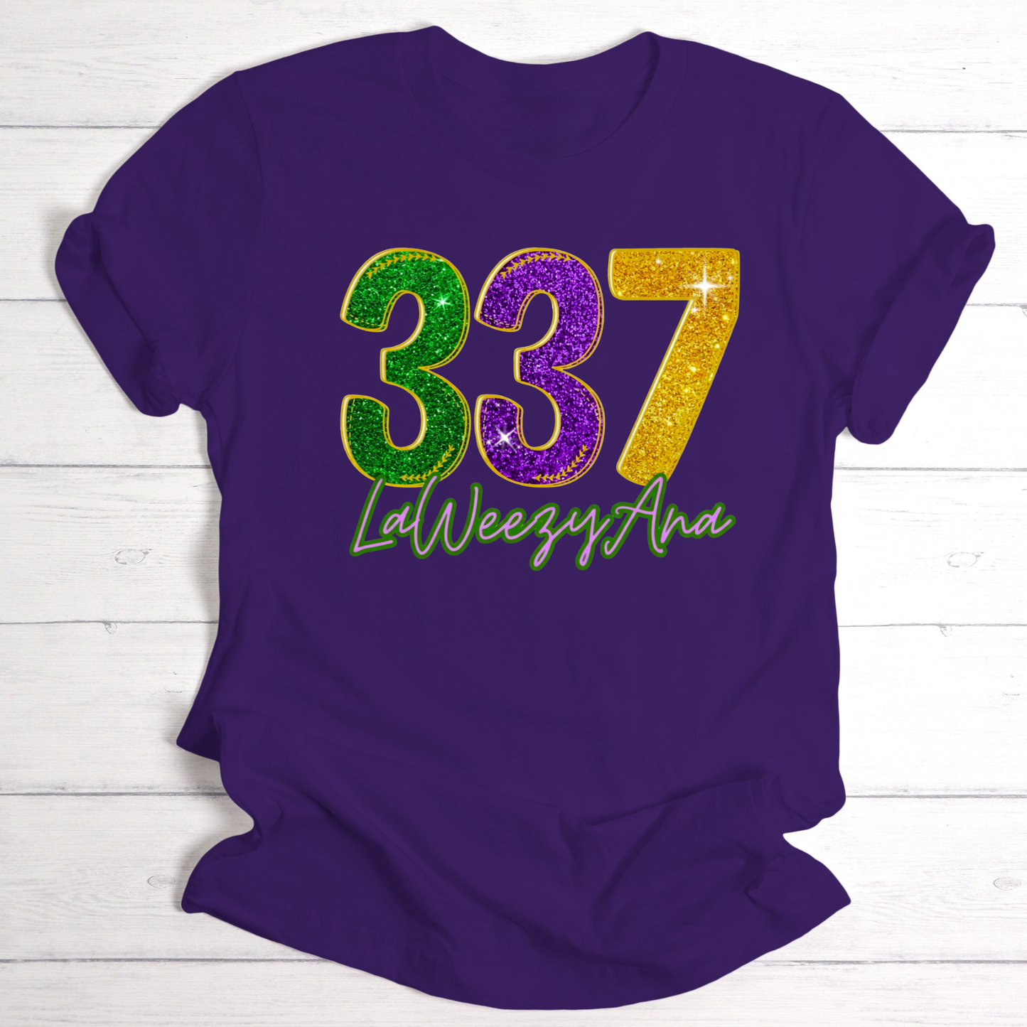 Purple t-shirt with colorful numbers '337' and text on a white wooden background
