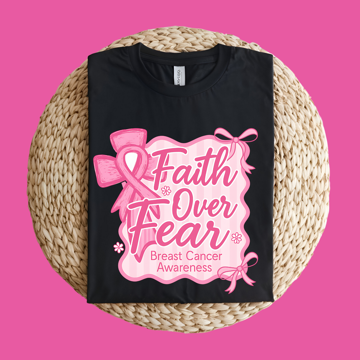 Black t-shirt with pink 'Faith Over Fear' breast cancer awareness design on a woven mat with a pink background  Pink Ribbon Tee: Faith Over Fear - Supportive Awareness T-shirt