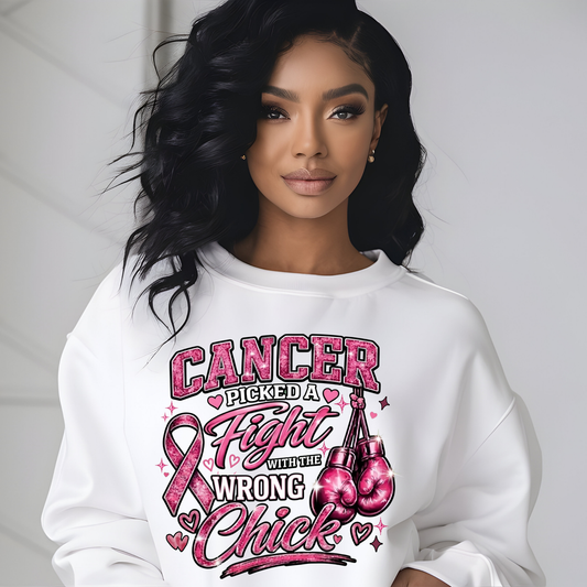 A woman wearing a white crewneck sweatshirt with a graphic print that reads 'HER Fight IS OUR Fight' in pink and black lettering, featuring three Black women and a pink ribbon. The background is a clean, light gray wall.