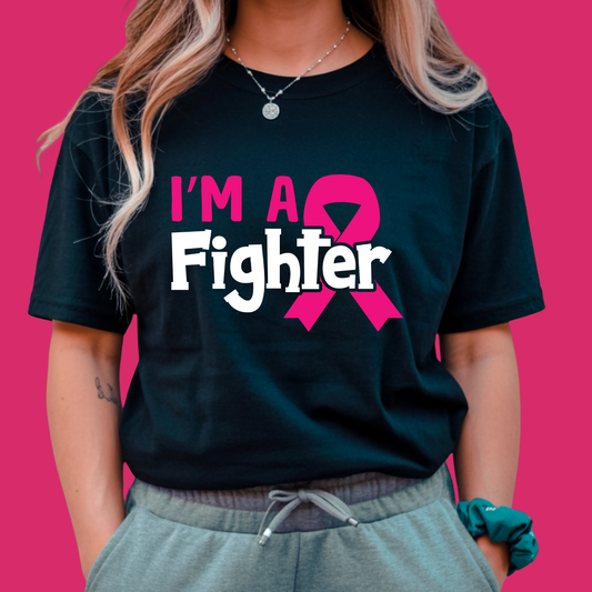 Person wearing a black t-shirt with 'I'm a Fighter' and a pink ribbon design on a pink background Pink Ribbon Tee: I'M A FIGHTER - Powerful Empowerment T-shirt