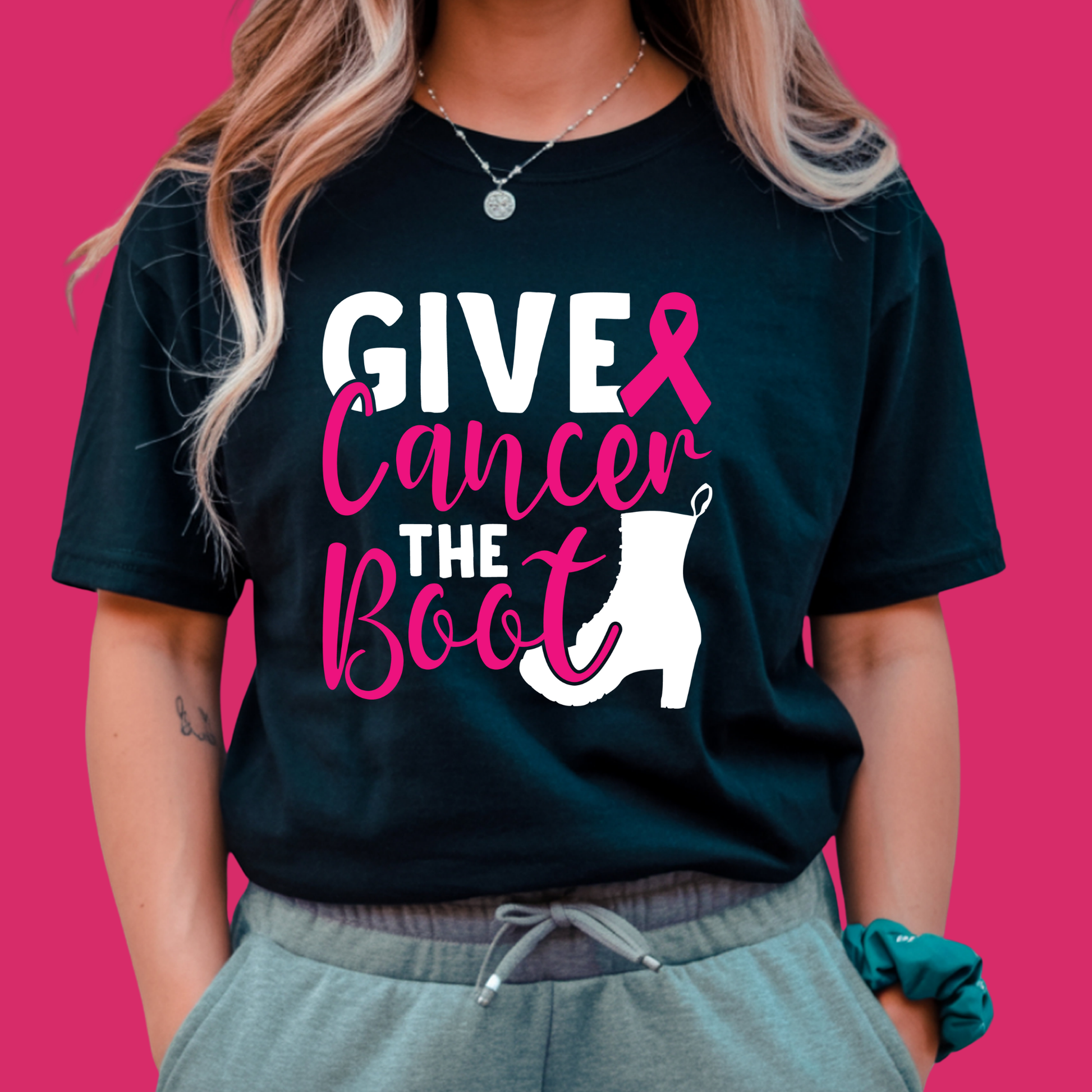 Person wearing a black t-shirt with 'Give Cancer the Boot' design on a pink background Pink Ribbon Tee: GIVE CANCER THE BOOT- Powerful Awareness Support T-shirt