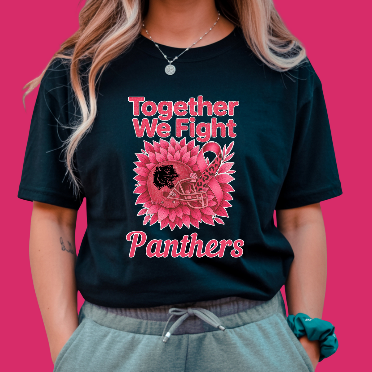 Person wearing a black t-shirt with pink graphics and text on a pink background Custom Pink Ribbon Football Tee: Together We Fight - Custom Mascot