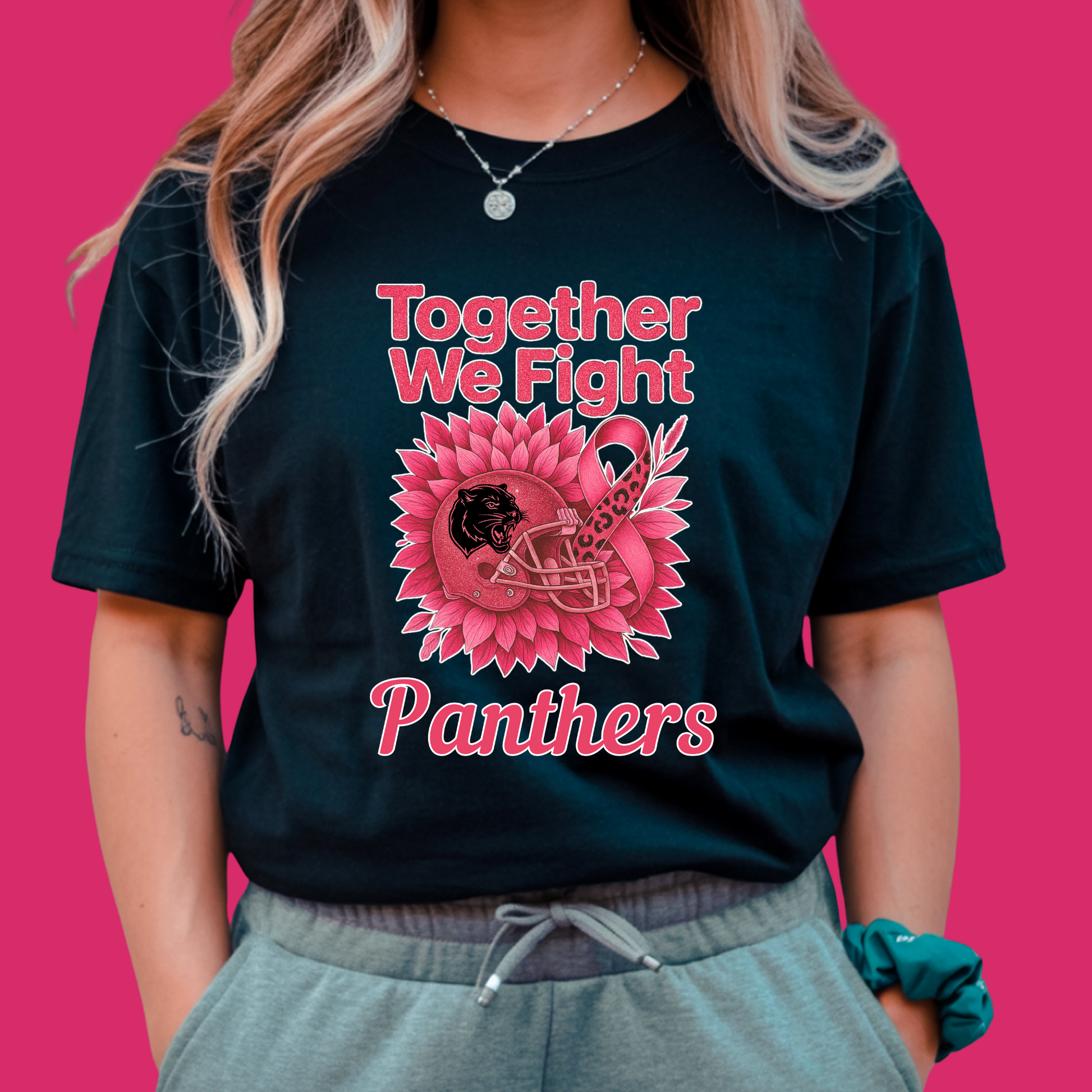 Person wearing a black t-shirt with pink graphics and text on a pink background Custom Pink Ribbon Football Tee: Together We Fight - Custom Mascot