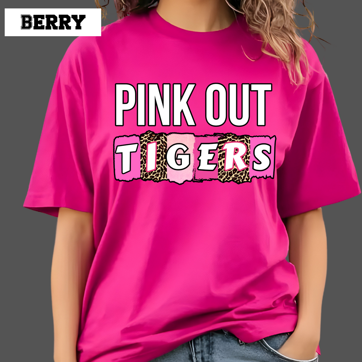 Person wearing a bright pink t-shirt with 'Pink Out Tigers' text on a gray background