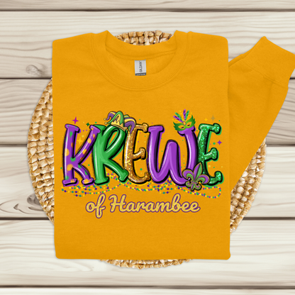 Yellow sweatshirt with 'Krew of Harambee' text on a wooden surface