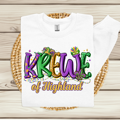 White t-shirt with 'Krewe of Highland' design on a woven mat