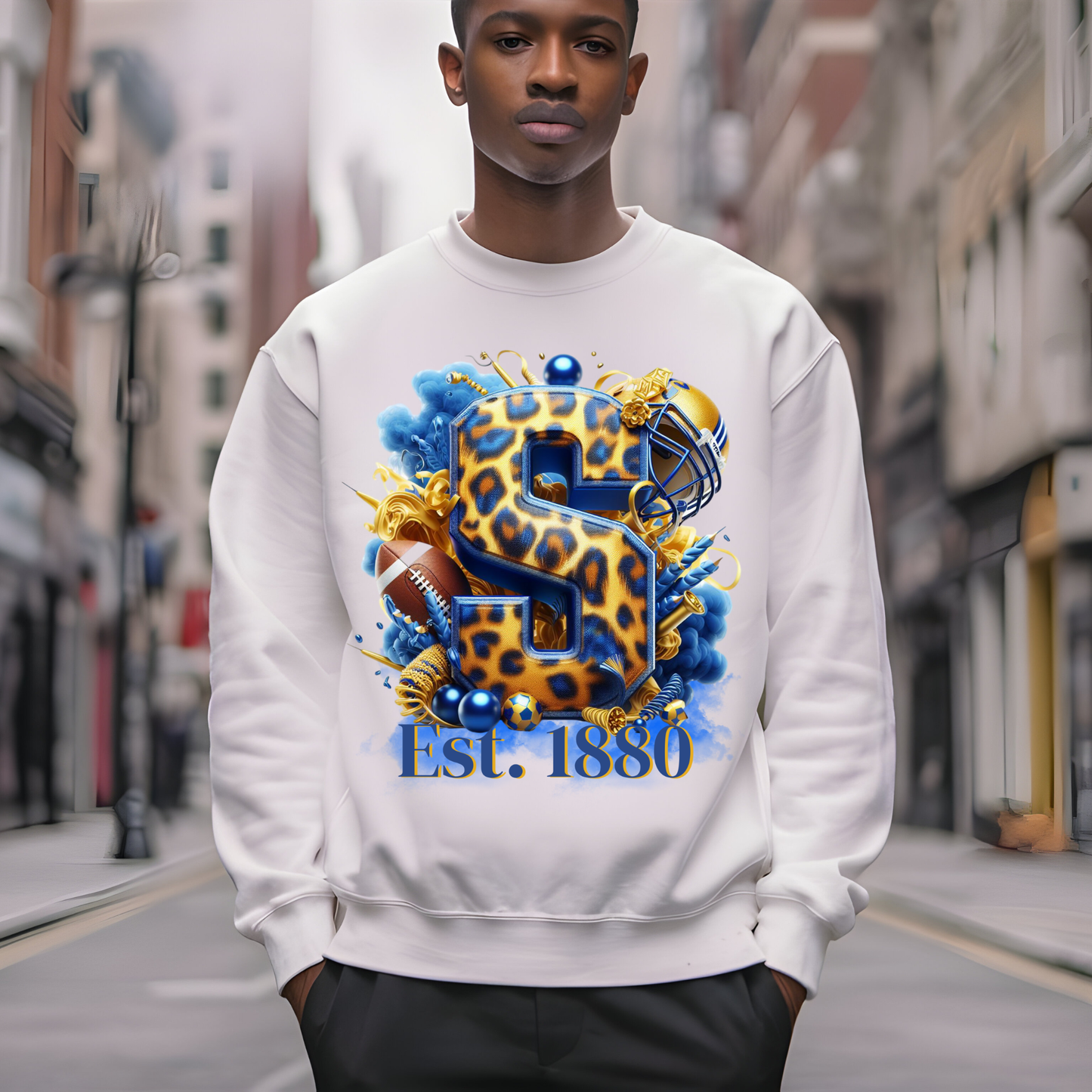 A man wearing a white crewneck sweatshirt with a large graphic print featuring a leopard-print letter 'S', a football helmet, a football, and the text 'Est. 1880' in a blurred urban street setting.