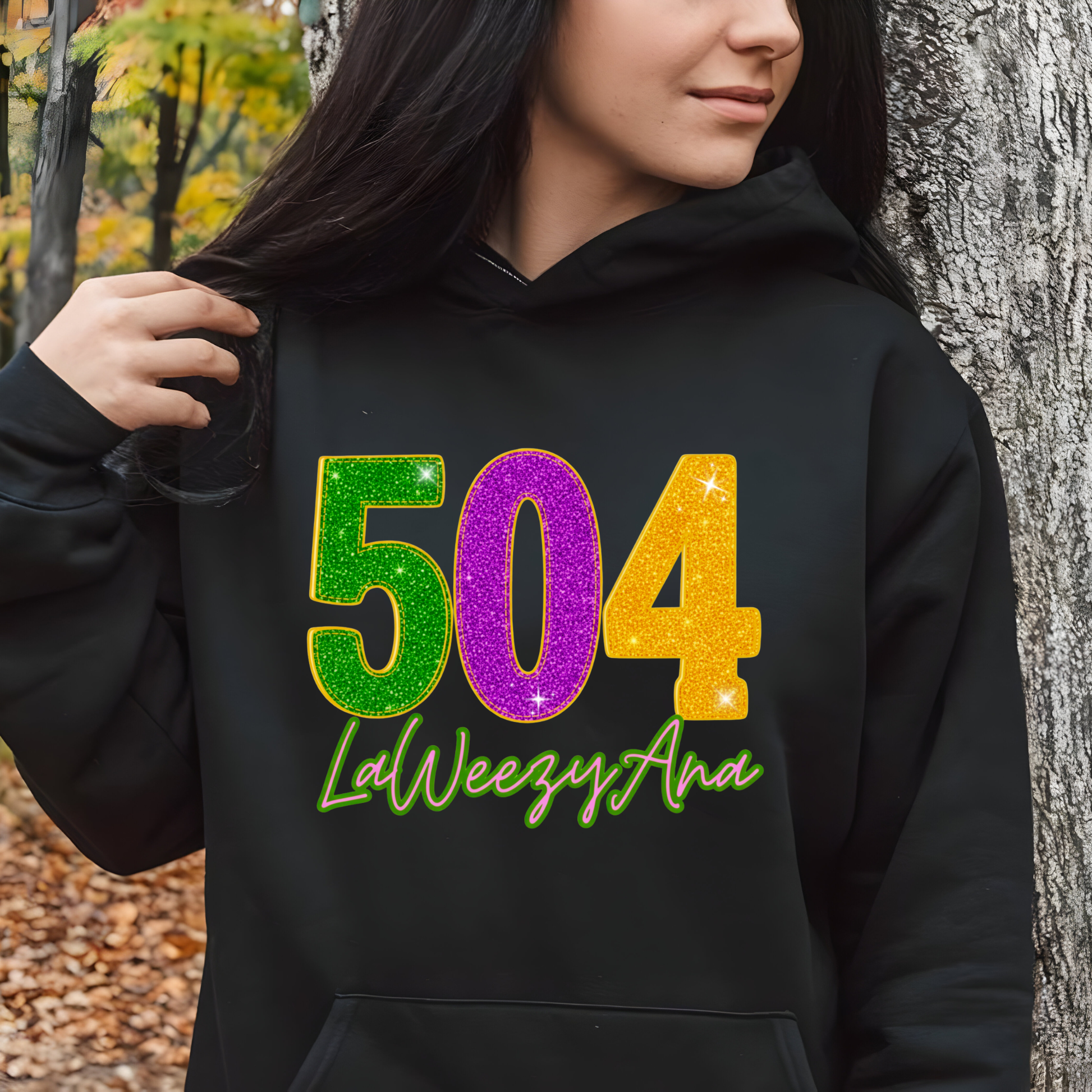 Person wearing a black hoodie with colorful numbers and text, standing outdoors.