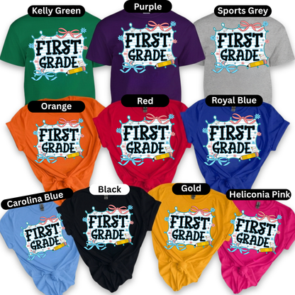 A collage showing multiple short-sleeve T-shirts in different colors, each with a large front graphic that reads “FIRST GRADE” in stylized lettering. Color labels above each shirt include Kelly Green, Purple, Sports Grey, Orange, Red, Royal Blue, Carolina Blue, Black, Gold, and Heliconia Pink.