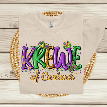 Beige t-shirt with 'Krewe of Centaur' text on a woven mat