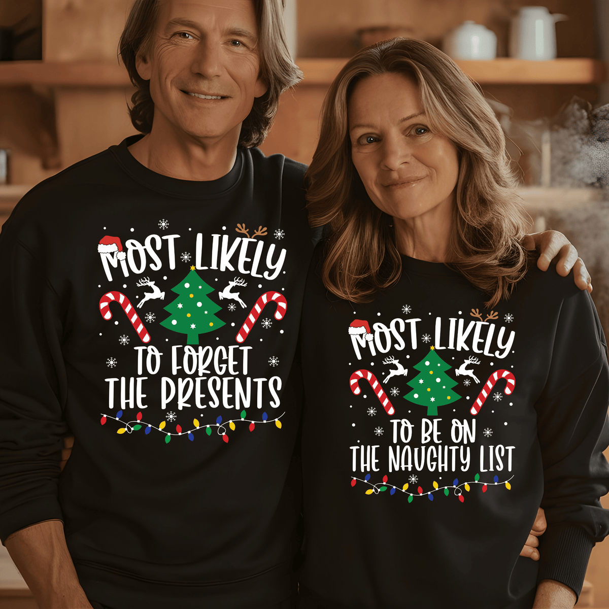A man and a woman wearing matching black Christmas sweatshirts with a festive graphic that reads 'MOST LIKELY TO FORGET THE PRESENTS' on the man and 'MOST LIKELY TO BE ON THE NAUGHTY LIST' on the woman. The graphic includes white text, a green Christmas tree, red-and-white candy canes, and multicolored holiday lights, set against a warm indoor background.