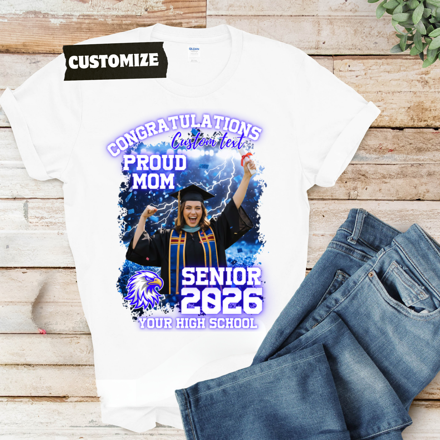 Graduation-themed t-shirt with customizable text on a wooden surface with jeans.