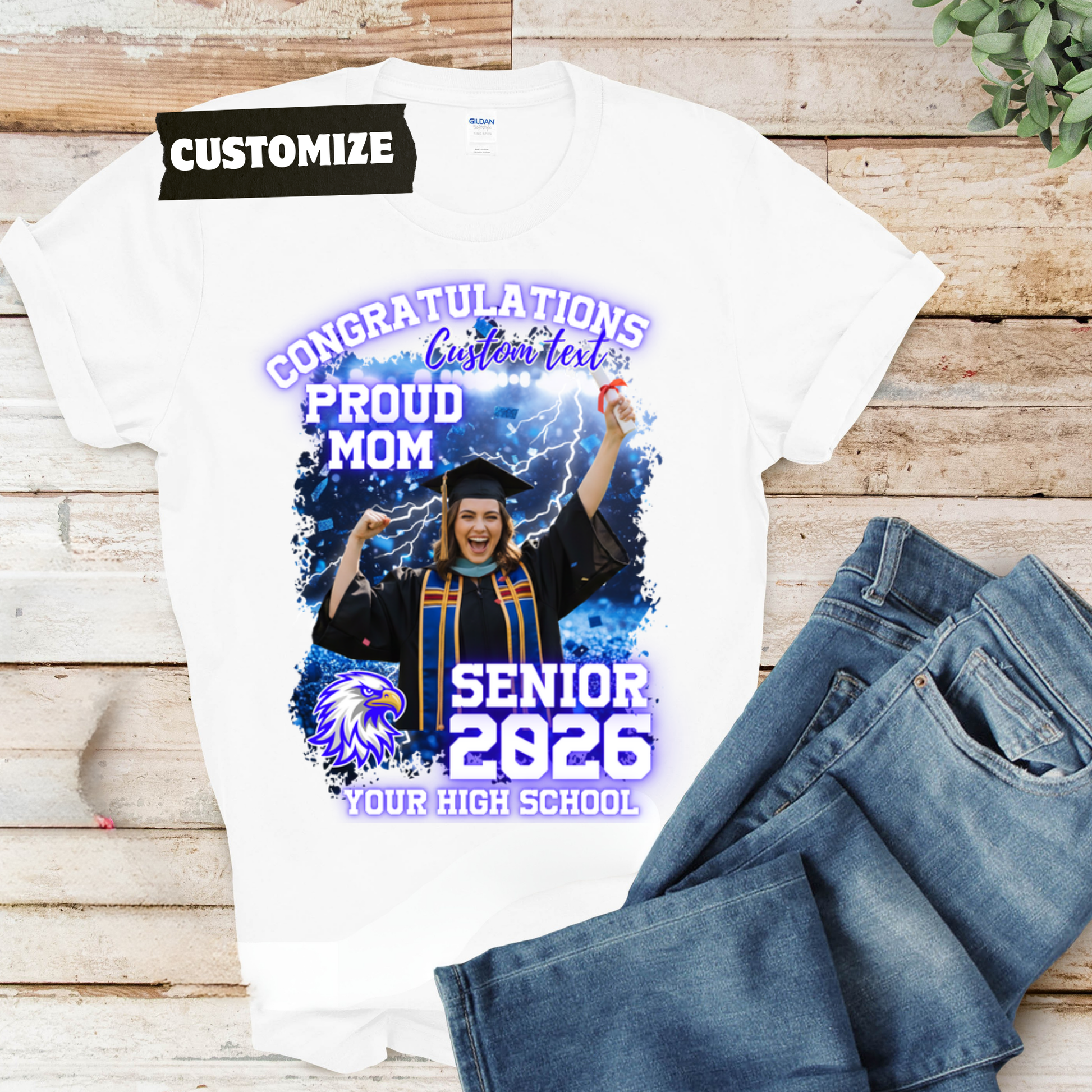 Graduation-themed t-shirt with customizable text on a wooden surface with jeans.