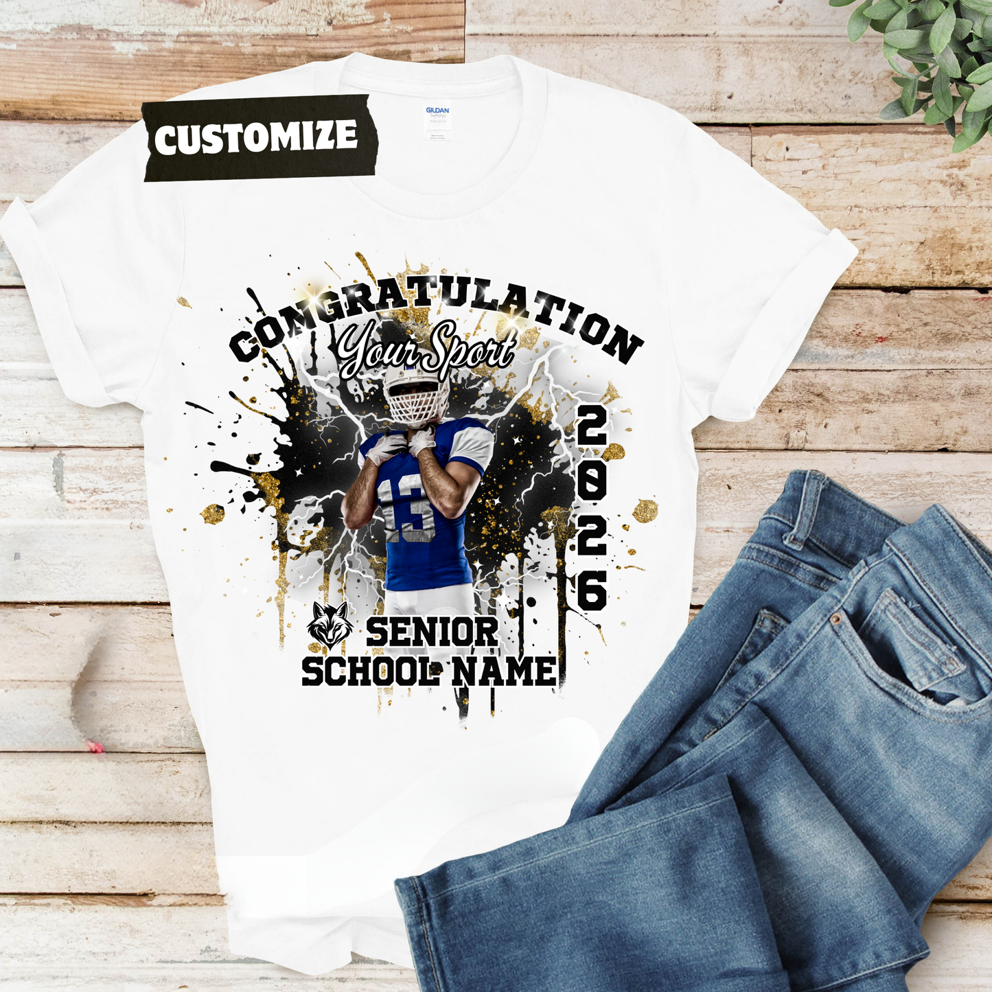 White t-shirt with customizable design of a football player, jeans on wooden surface  Customizable graduation photo t-shirt featuring senior portrait, school mascot, and sports organization logos in school colors