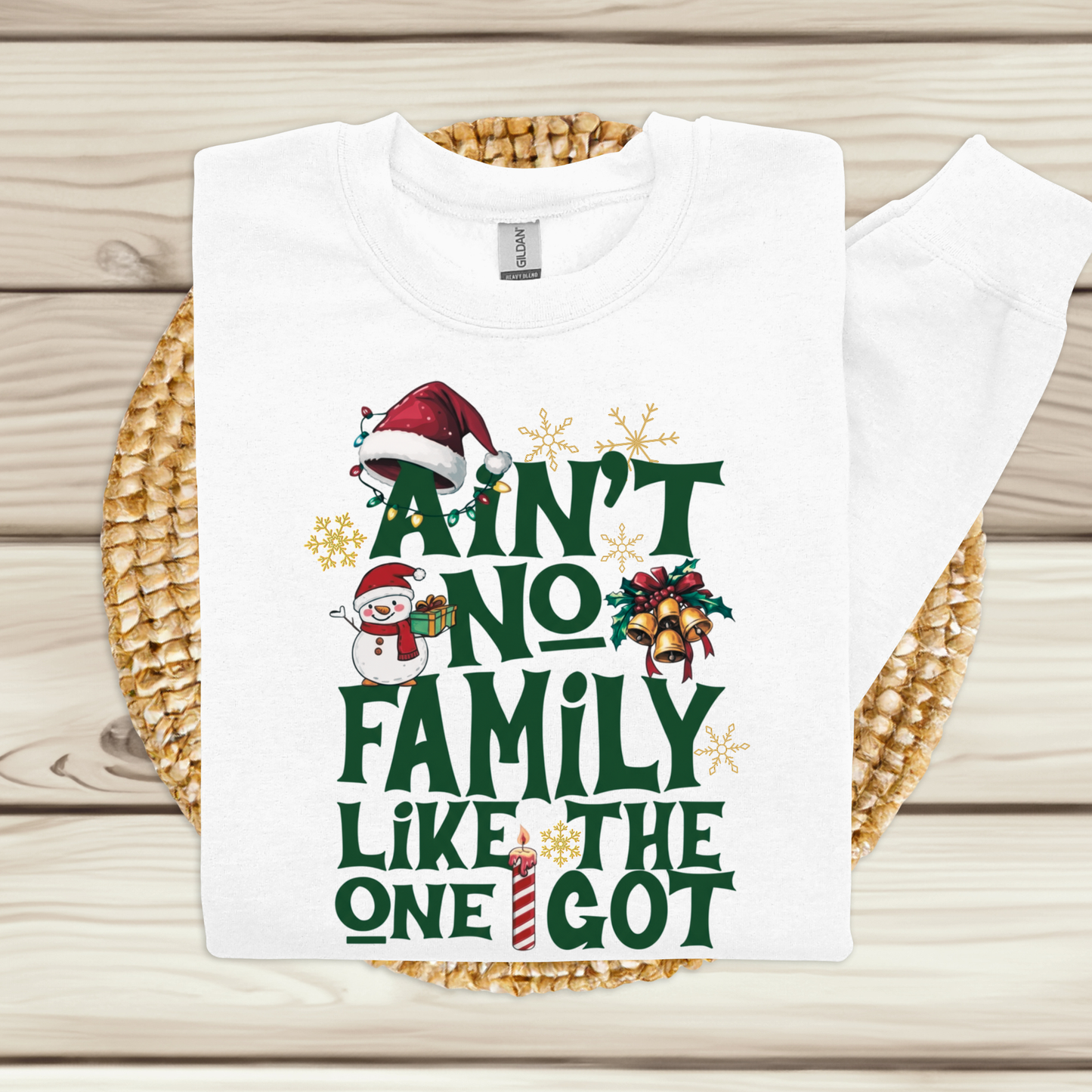 White t-shirt with Christmas-themed text and graphics on a woven mat.