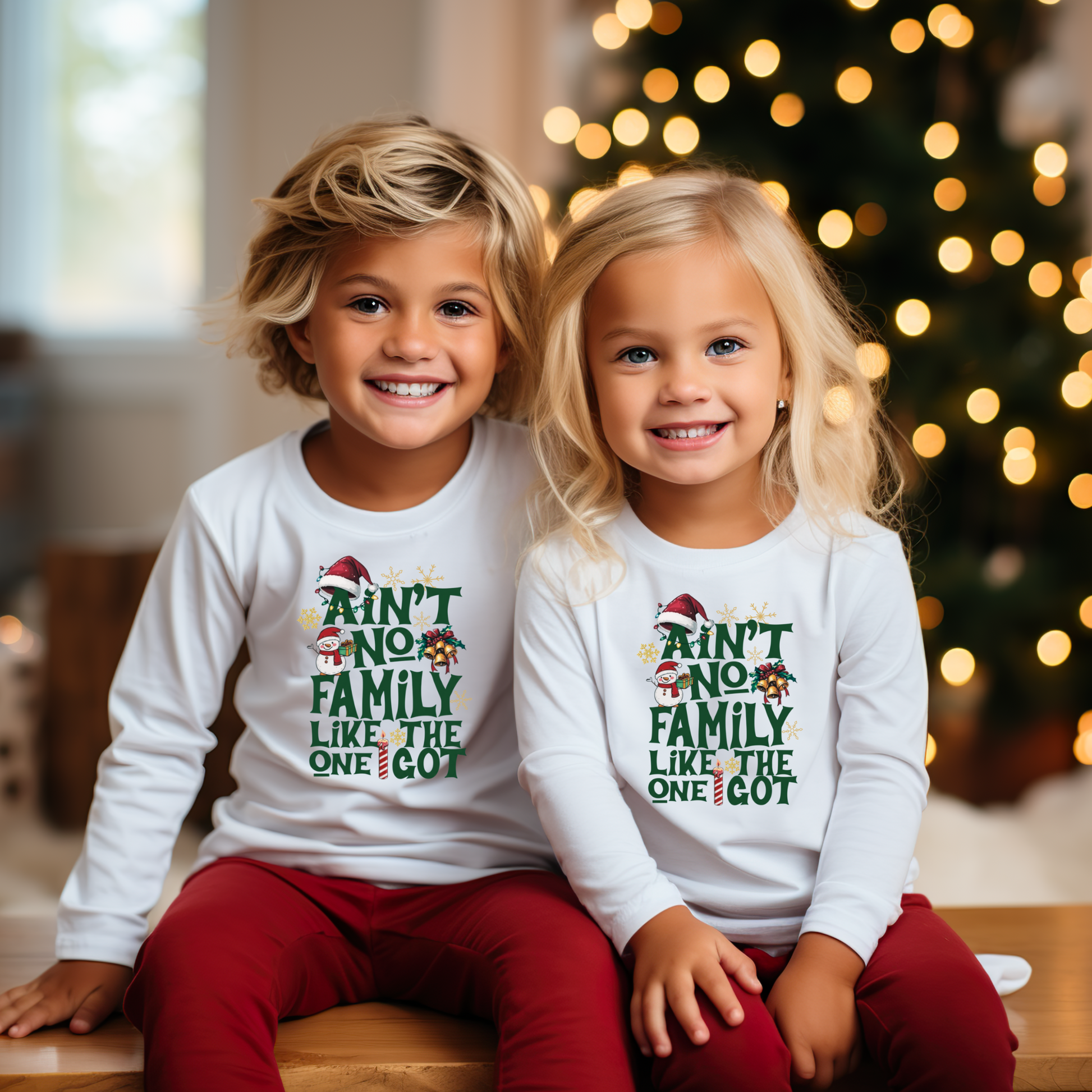 Two children wearing matching Christmas-themed shirts in front of a decorated tree.