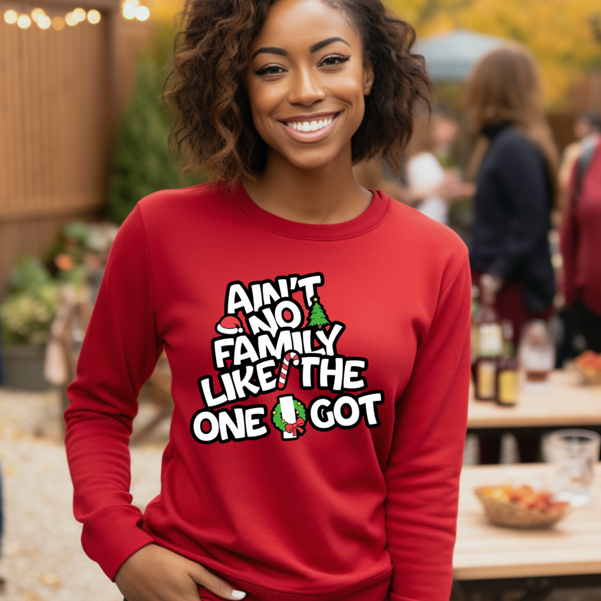 Woman wearing a red sweatshirt with a humorous text design outdoors.