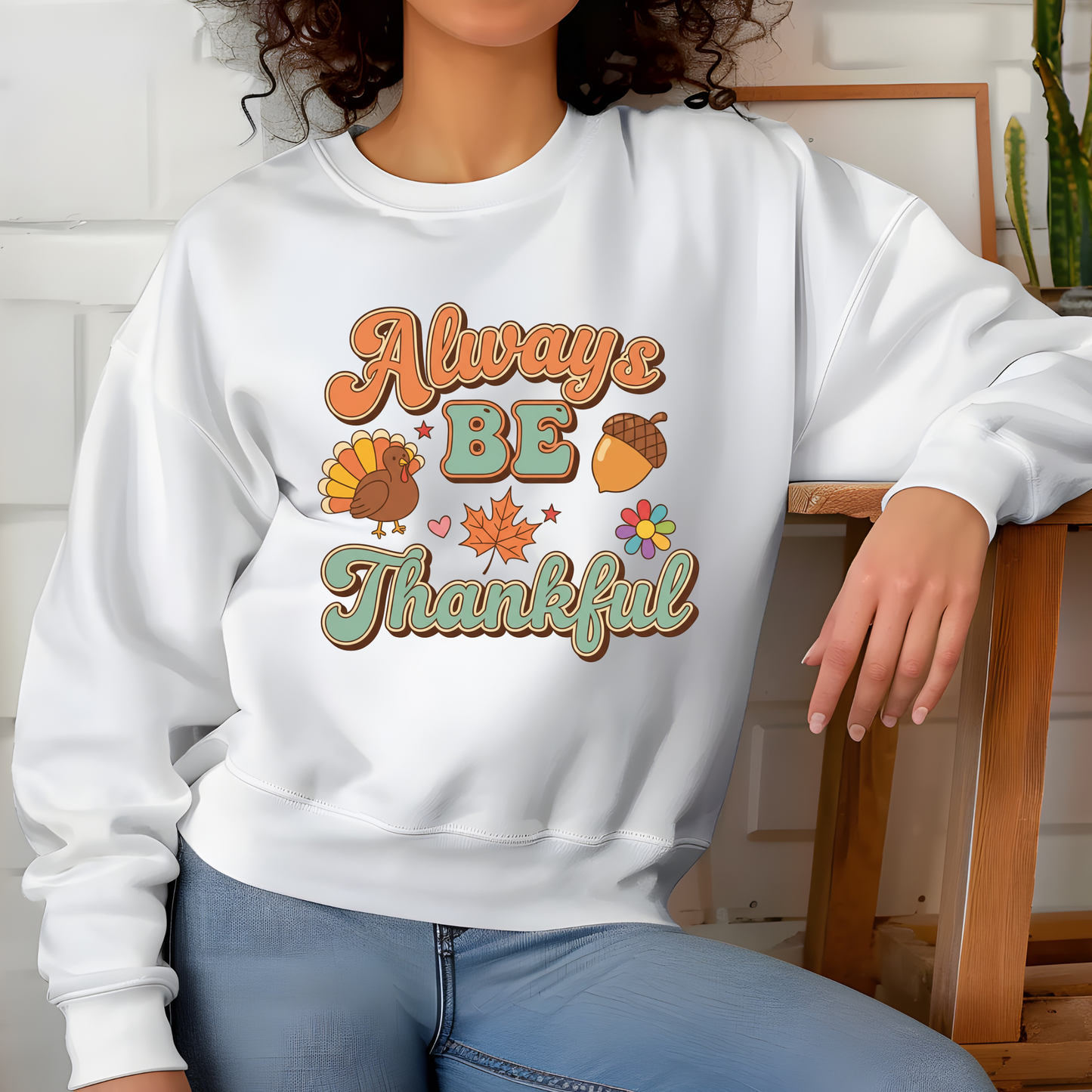 Person wearing a white sweatshirt with 'Always Be Thankful' text and graphics. Retro Thanksgiving Sweatshirt "Always Be Thankful" Fall Harvest Crewneck Sweater