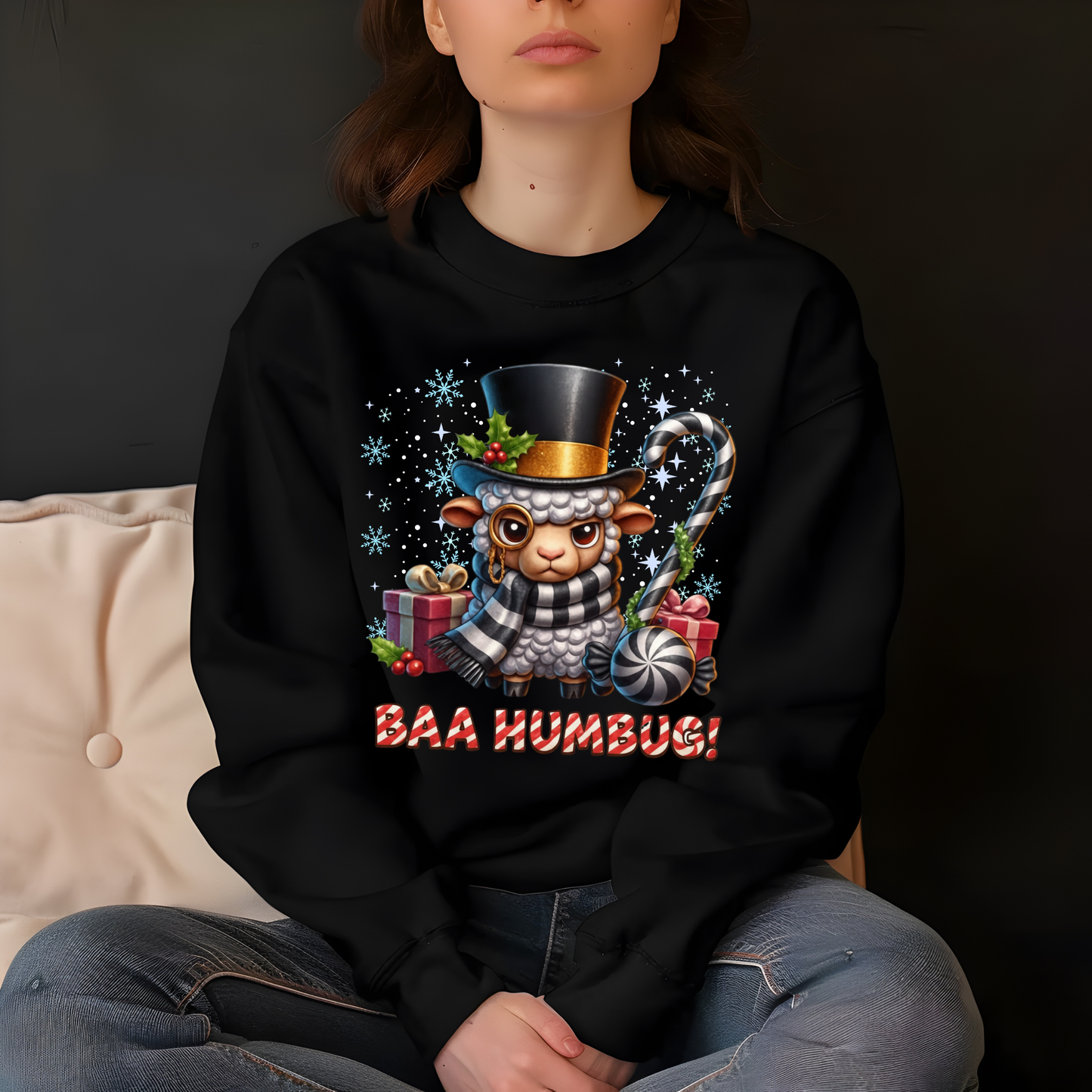 Person wearing a black sweatshirt with a Christmas-themed design featuring a lamb in a top hat and scarf, sitting on a couch.