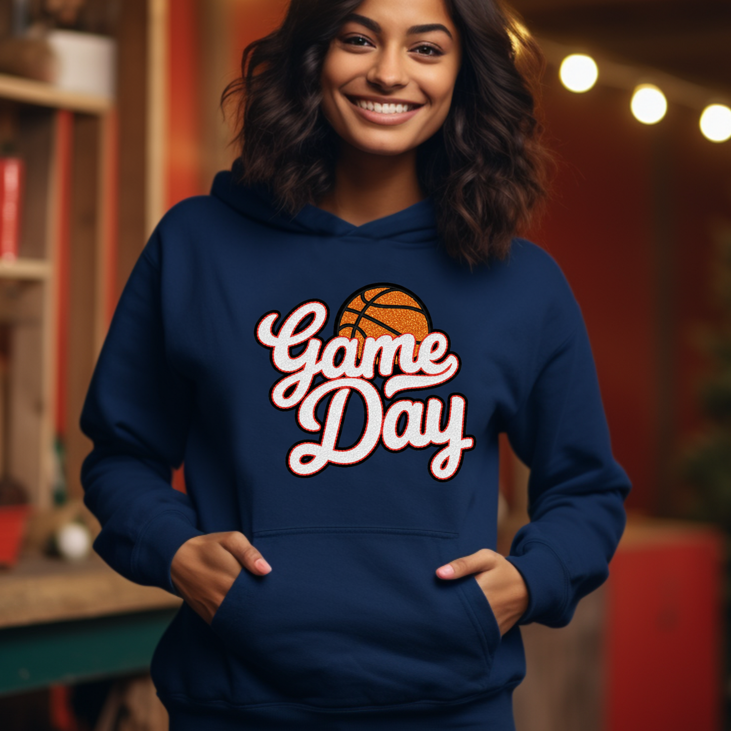 Person wearing a blue hoodie with 'Game Day' and basketball graphic, indoors.