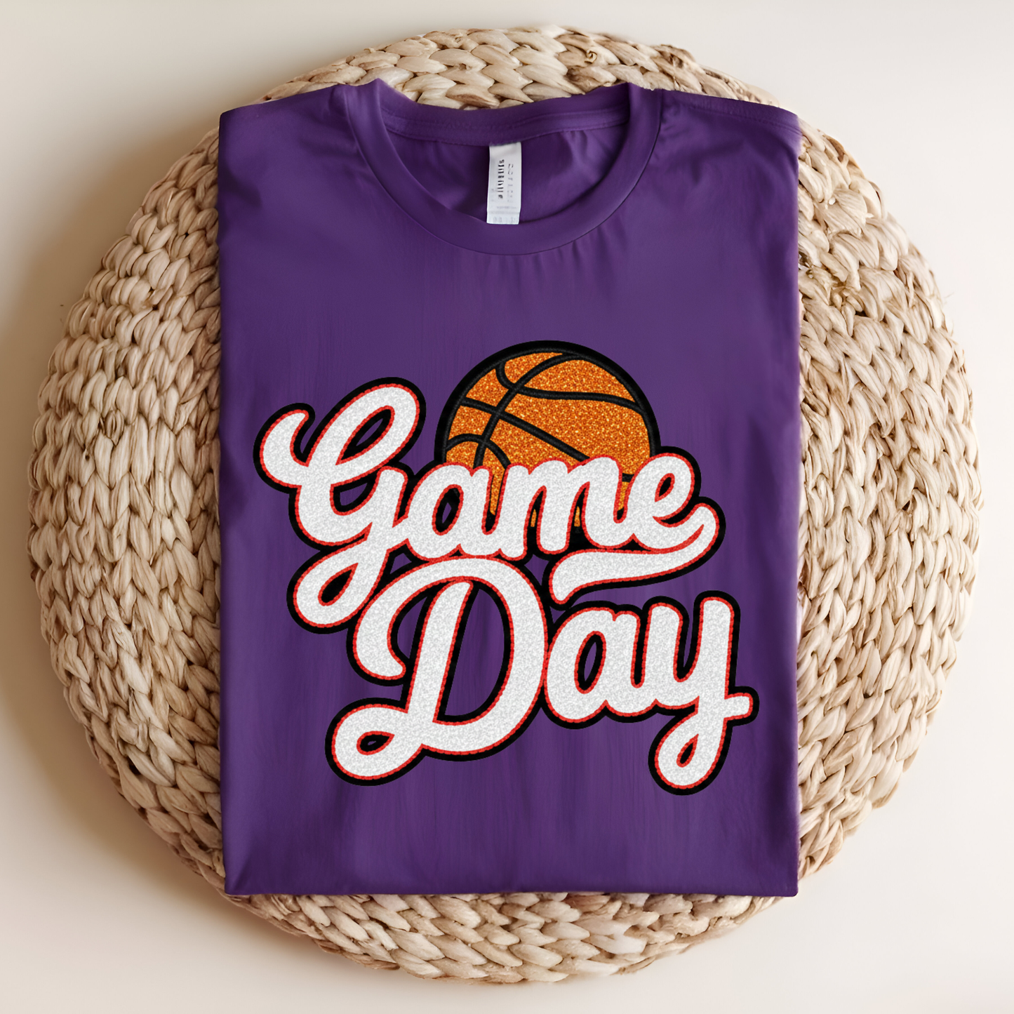 Purple t-shirt with 'Game Day' and basketball graphic on a woven mat