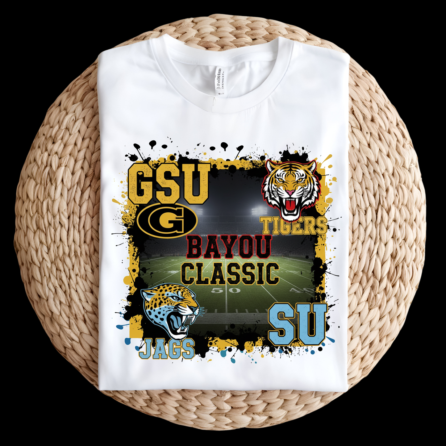 White t-shirt with sports-themed design featuring a tiger and Jaguars logo on a woven surface. Bayou Classic Football T-Shirt - Grambling State GSU Tigers vs. Southern University SU Jags Tee
