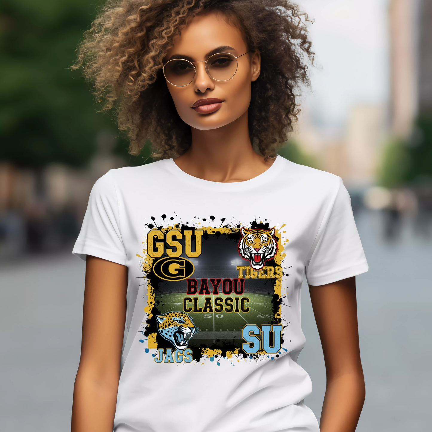 Woman wearing a white t-shirt with sports team graphics and text. Bayou Classic Football T-Shirt - Grambling State GSU Tigers vs. Southern University SU Jags Tee