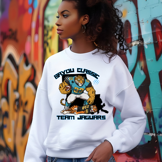 Person wearing a white sweatshirt with a 'Team Jaguars' graphic in front of a graffiti wall. Bayou Classic Team Jaguars: Bayou Classic HBCU Jaguars Game Day Sweater