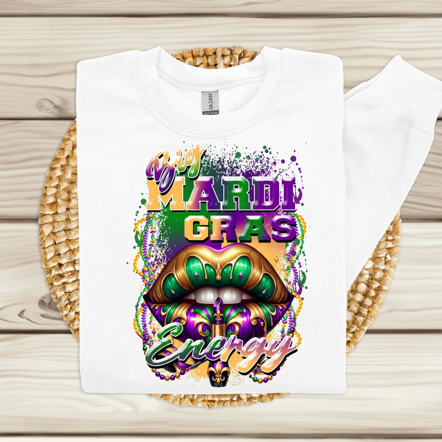 White t-shirt with Mardi Gras-themed design on a wooden surface