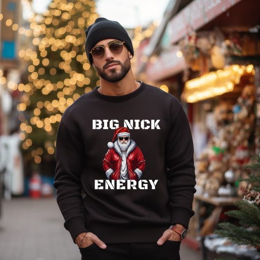 Man wearing a black sweatshirt with a graphic design and text, standing in a festive outdoor setting.