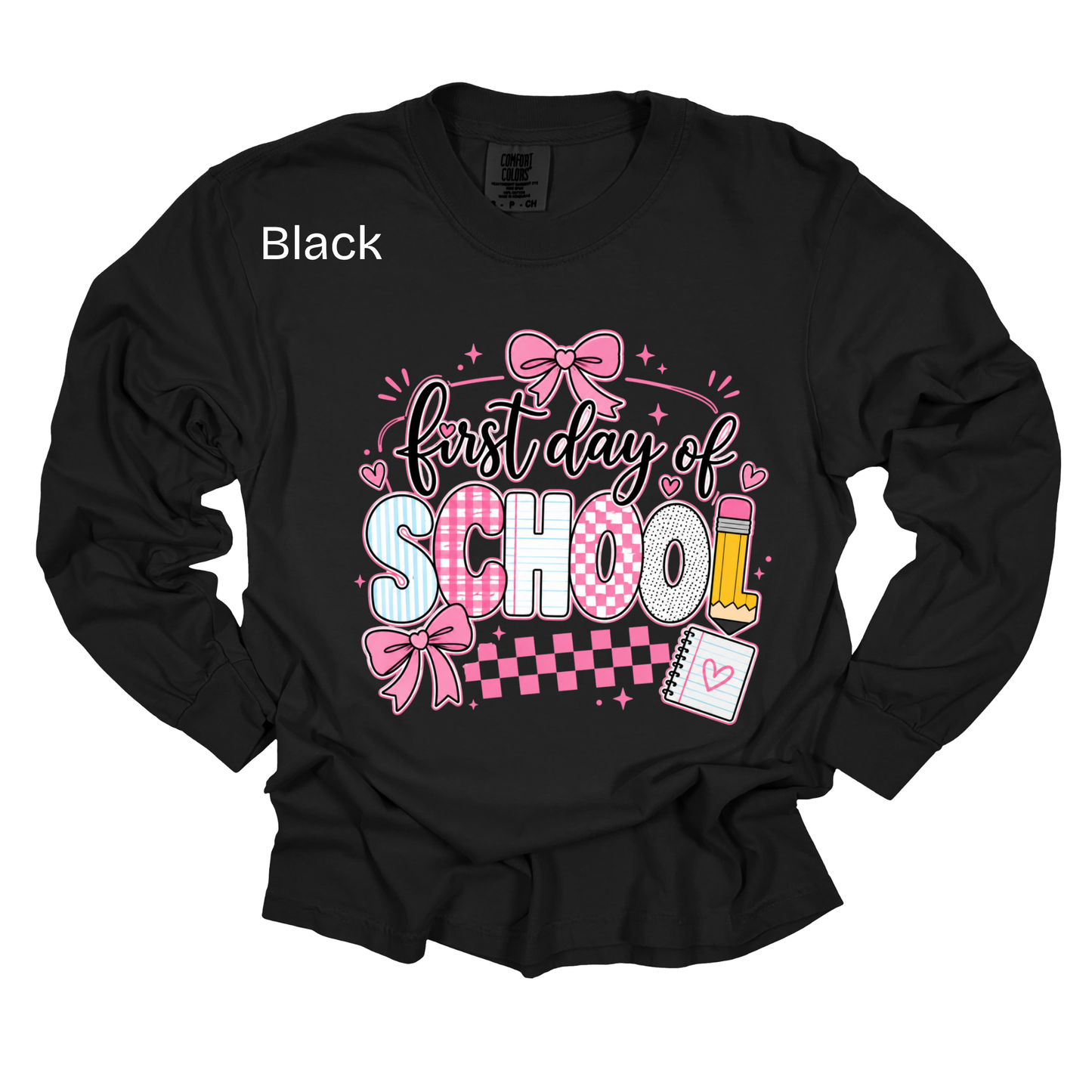 A black long-sleeve t-shirt with a 'First day of SCHOOL' graphic on the front, featuring pink bows, checkered patterns, and school-themed illustrations. The word 'Black' is printed in white on the upper left chest.