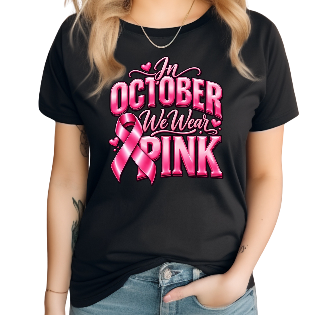 A woman wearing a black short-sleeve t-shirt with a pink graphic that reads 'Breast Cancer WARRIOR' with a pink ribbon and boxing gloves, paired with blue jeans against a white background.