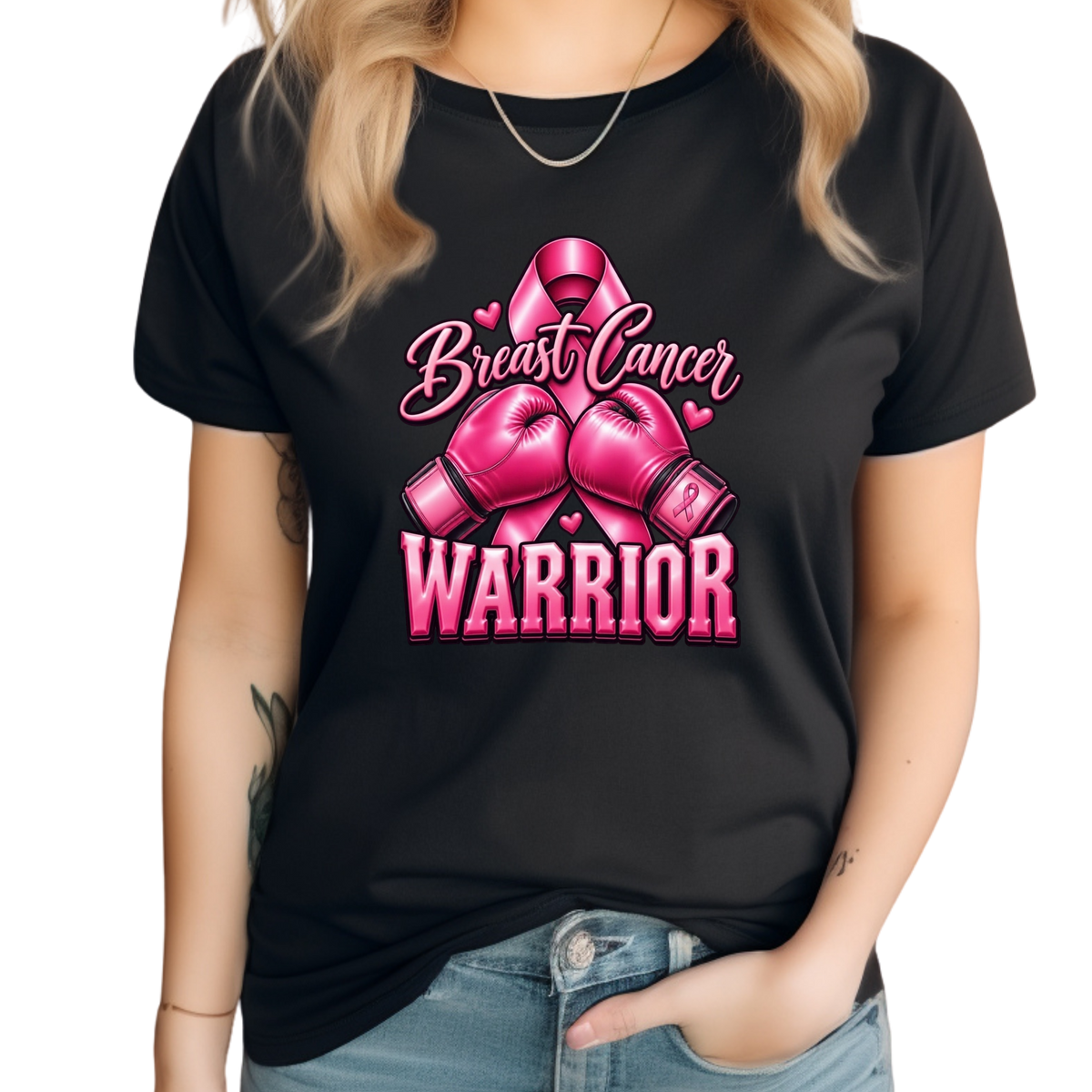 A woman wearing a black short-sleeve t-shirt with a pink graphic that reads 'Breast Cancer WARRIOR' with a pink ribbon and boxing gloves, paired with blue jeans against a white background.