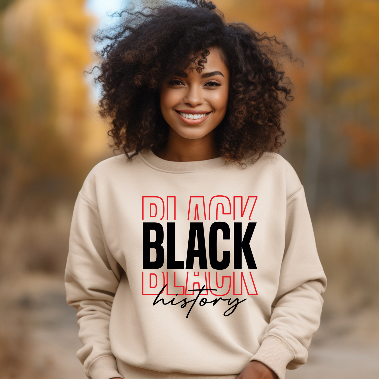 Person wearing a beige sweatshirt with 'BLACK HISTORY' text in an outdoor setting