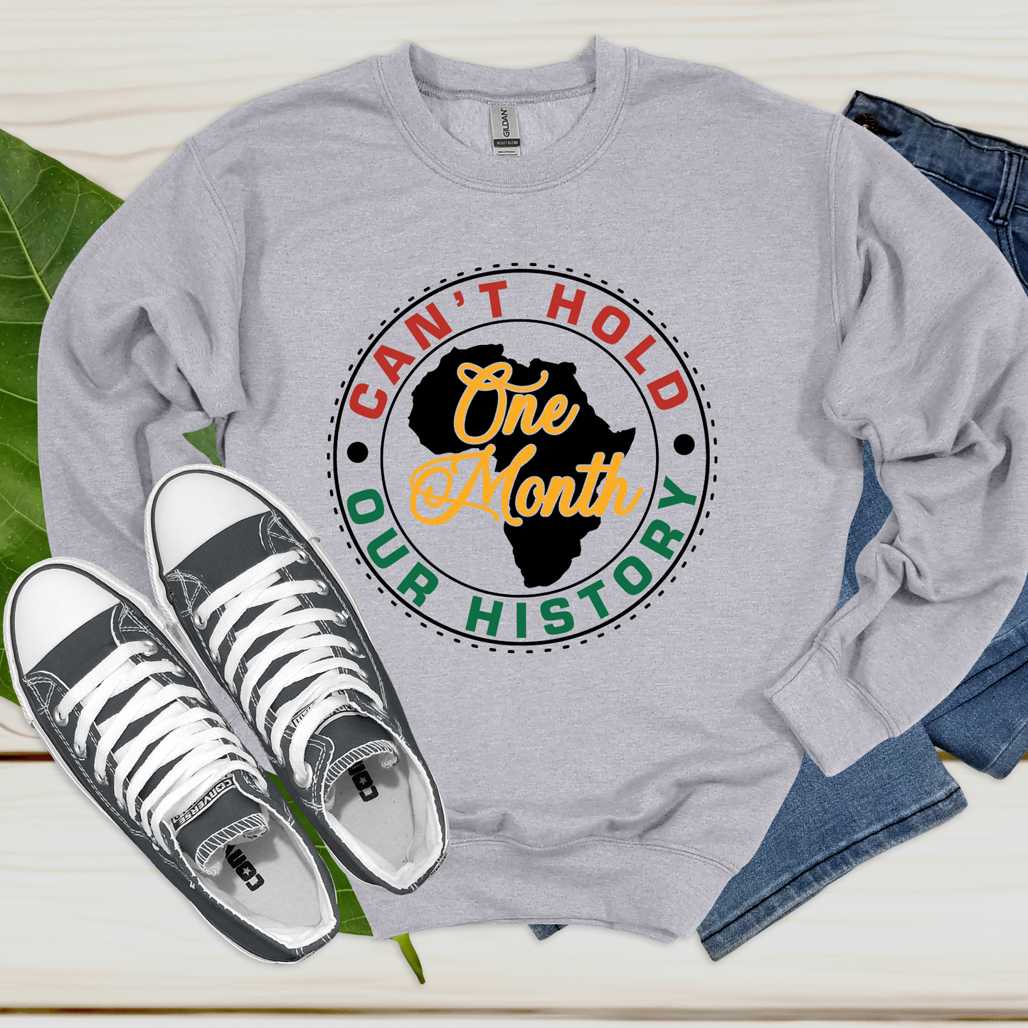 Black Women wearing grey warm crewneck sweatshirt sweater with the phrase One Month Can't Hold our history in support of Black Culture and Black History Month Celebration parades 