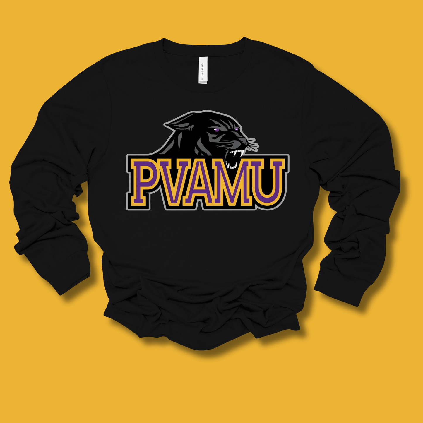 A black long-sleeve crewneck sweatshirt featuring a stylized black panther graphic and the text 'PVAMU' in purple and gold outlined block letters across the chest, displayed against a solid mustard yellow background.