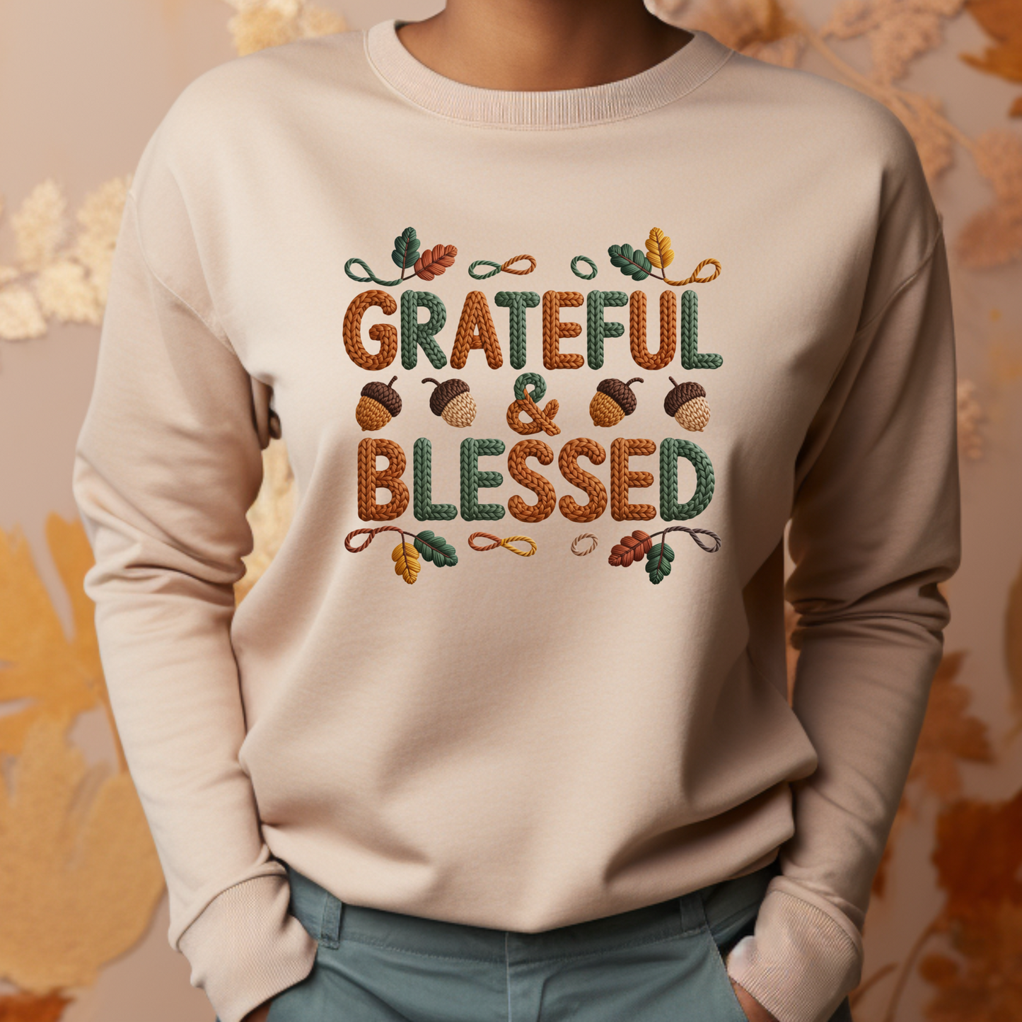Beige sweatshirt with 'Grateful & Blessed' text and autumn-themed design on a neutral background
