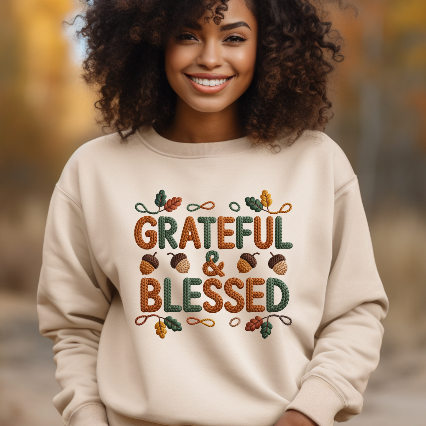 Woman wearing a beige sweatshirt with 'Grateful & Blessed' text and autumn-themed design outdoors.