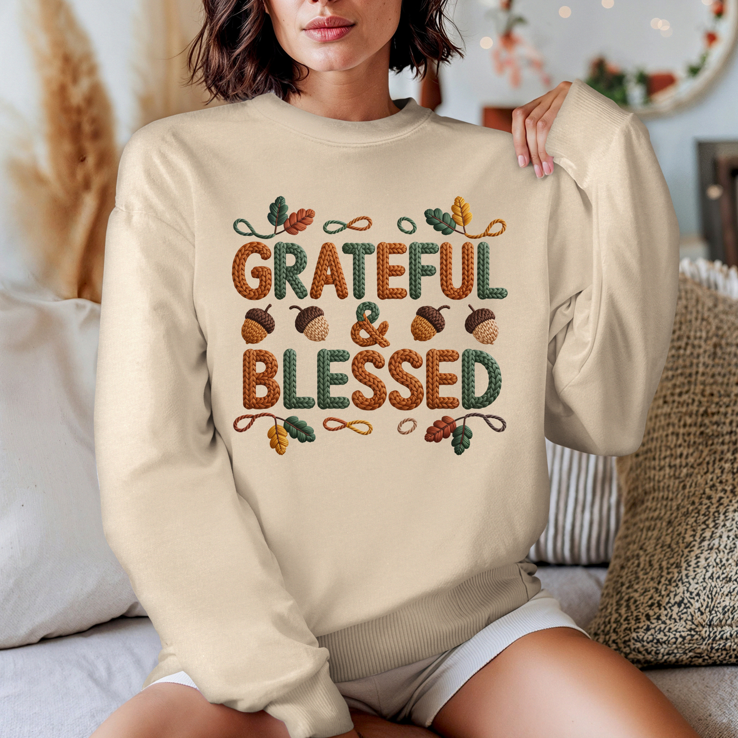 Person wearing a beige sweatshirt with 'Grateful & Blessed' text and autumn-themed design.