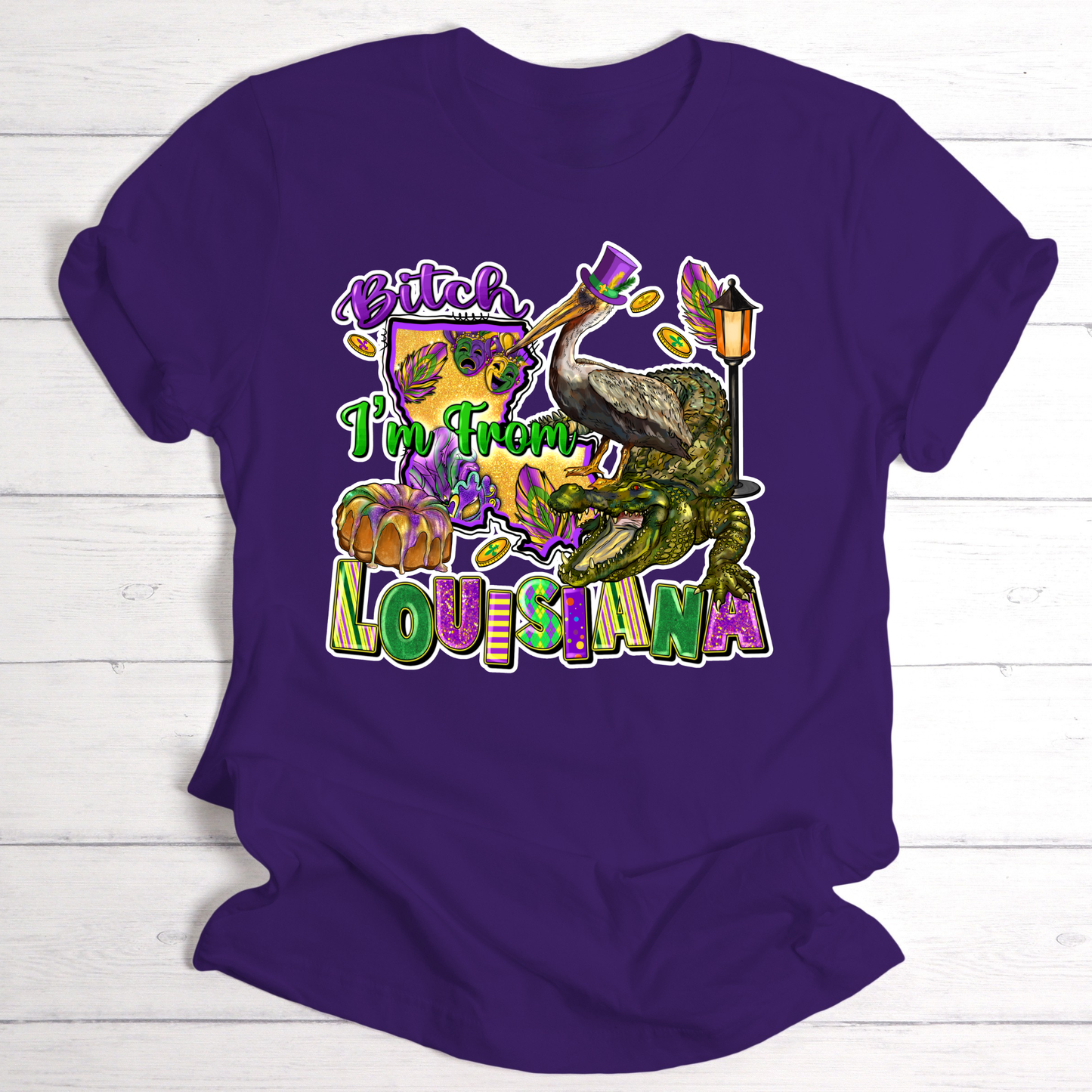 Purple t-shirt with a colorful graphic and text on a white wooden background