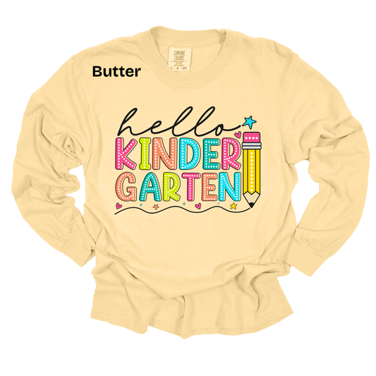 A pale butter-yellow long-sleeve t-shirt with a colorful graphic reading 'hello KINDER GARTEN' and a pencil illustration. The word 'Butter' is printed in black near the upper left chest, indicating the fabric color.