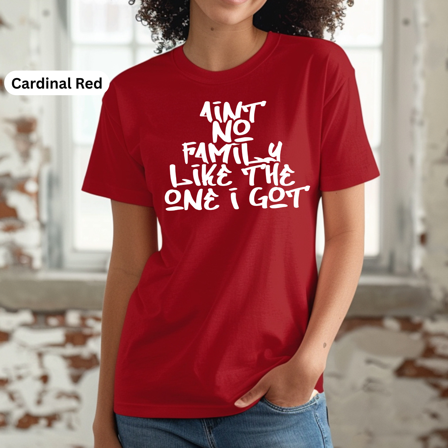 Person wearing a red t-shirt with white text in a blurred indoor setting